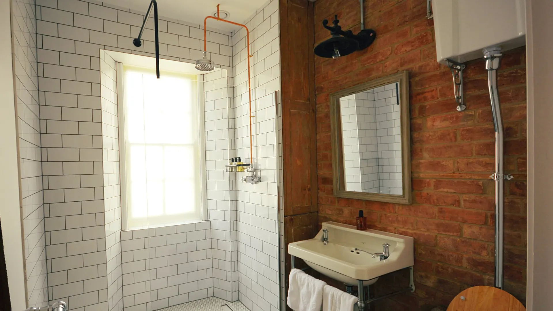 Exposed brick and white tiling in the Art Deco bathroom