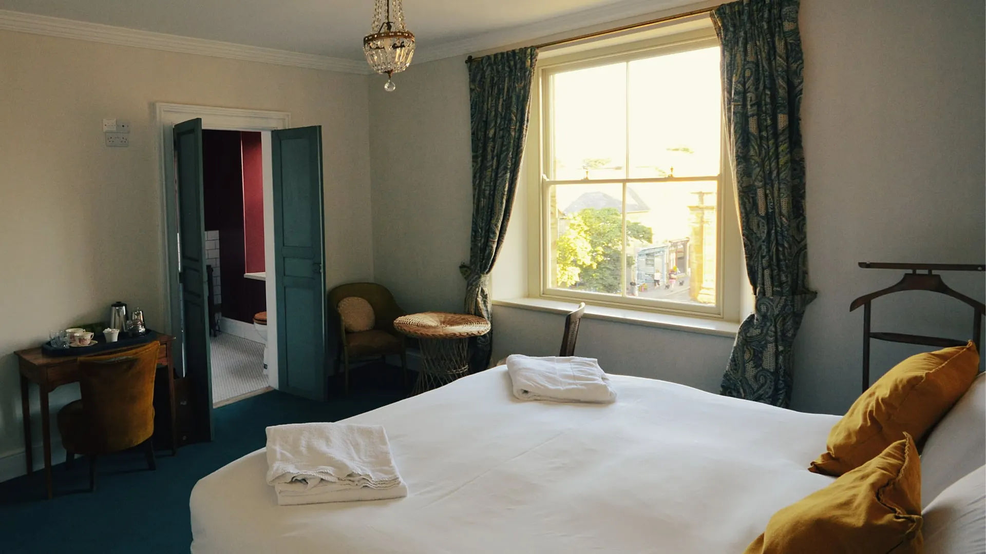 The Bold Red room, with teal curtains and a window seat