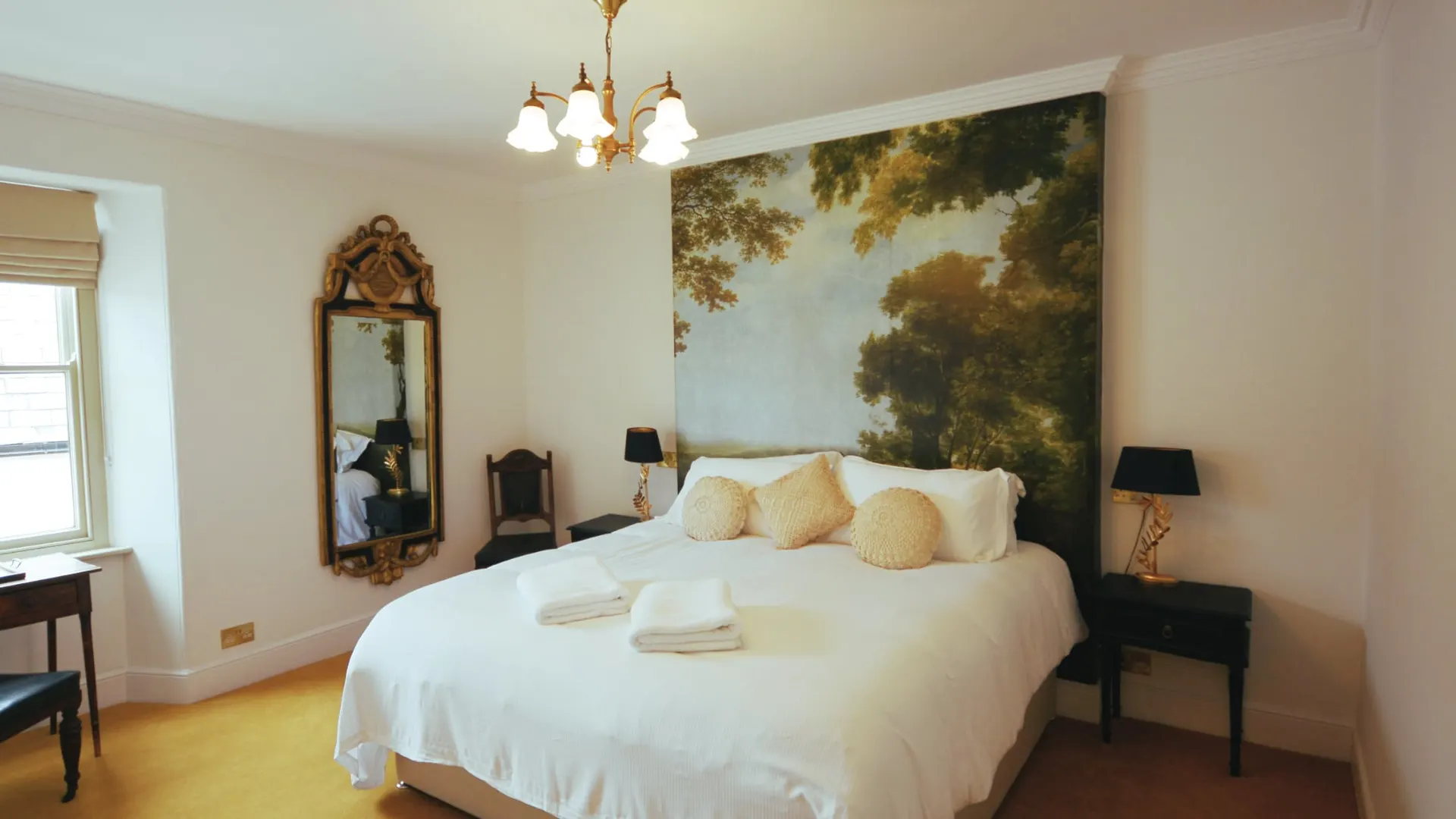 The Exposed Wall room seen from the window, with mirror and chandelier