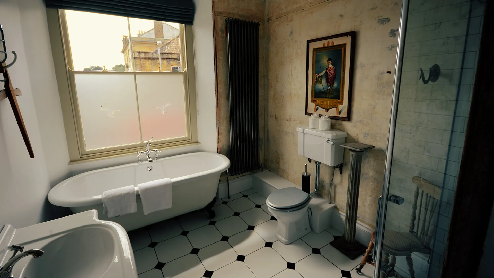 Roll-top bath on a chequerboard floor in the Four Poster room